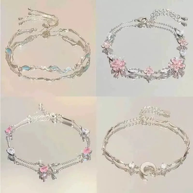 Close-up of adjustable gold bracelets with floral, leaf, and minimalist seasonal charms.